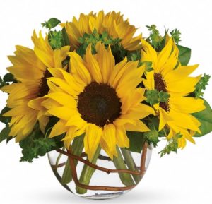 round glass vase with yellow sunflowers