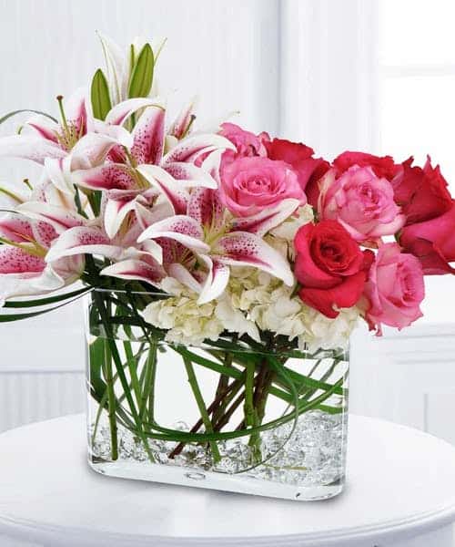 Delight her senses when you send this fragrant bouquet of pink & red roses, white hydrangea and Stargazer lilies with clear gemstones in the bottom of the vase